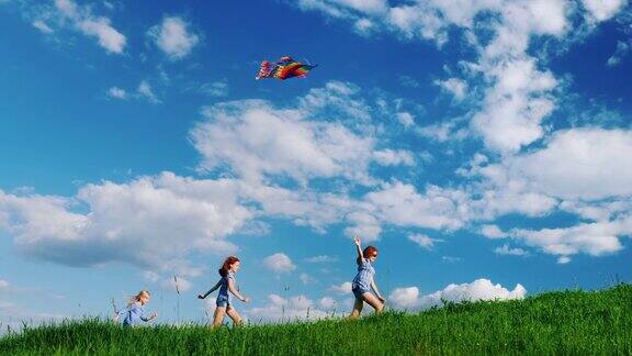 无忧无虑的孩子们玩着风筝在蓝天白云的映衬下沿着绿色的小山奔跑快乐的童年