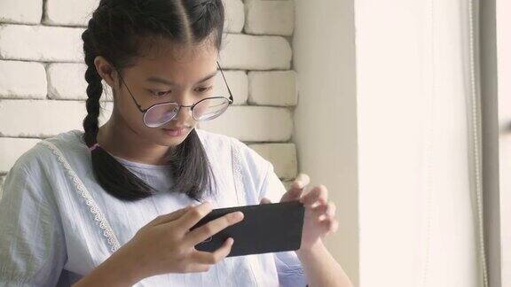 一个亚洲女孩在玩手机游戏