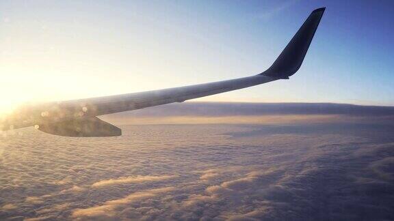夕阳从飞机窗口飞向天空的机翼