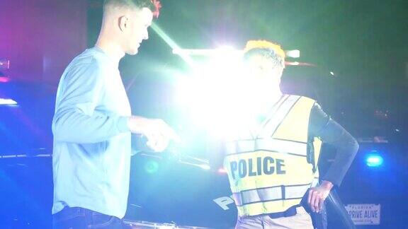 女警察在晚上和年轻男子谈话