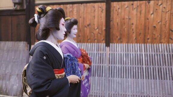 两名艺妓一起走在京都祗园的街道上