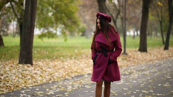优雅的女子漫步在秋天的公园里