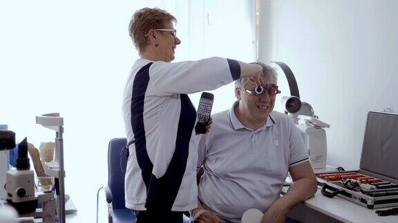 一名成年男子在眼科诊所用光学试验架检查视力