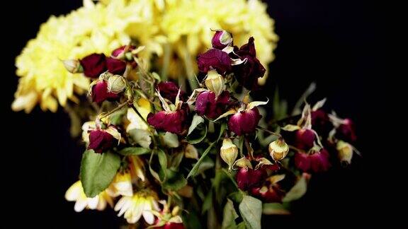枯萎干燥的红玫瑰花束黑色背景上的黄菊花