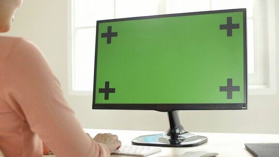 在家里使用绿屏电脑的妇女