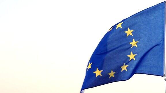 蓝色的旗帜上有一圈十二颗金星象征着欧洲各民族的团结一致在蓝天的映衬下旗杆上飘扬着欧盟国旗