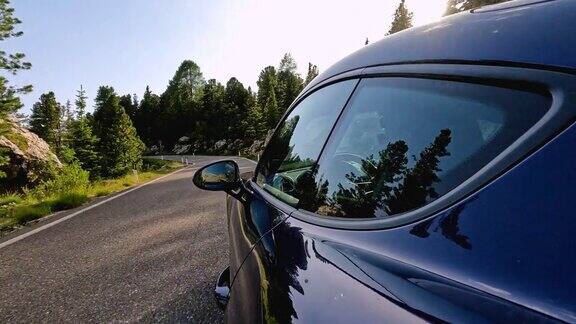蓝色跑车行驶在风景秀丽的山路上