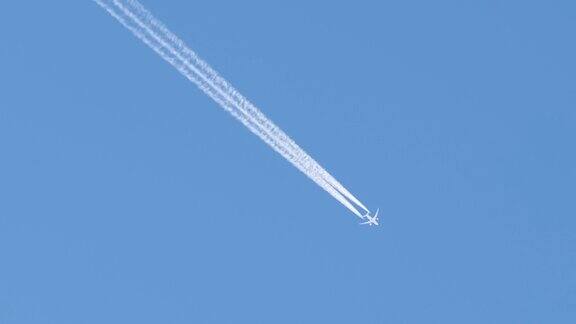 远处的喷气式客机在晴空万里的高空飞行留下白色的烟雾和尾迹航空运输