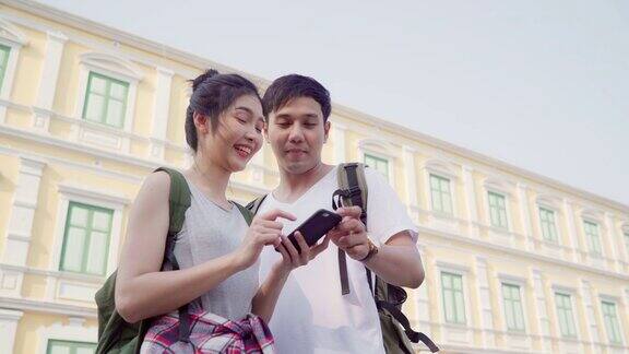 旅行者亚洲夫妇在曼谷的位置地图上的方向泰国夫妇使用手机在地图上寻找地标而花假期旅行生活方式夫妇旅游在城市