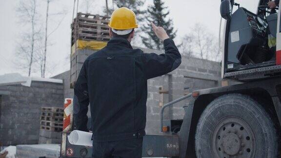 建筑工人向建筑地盘的吊车操作员发出信号