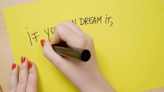 年轻女孩的手写如果你能梦想你可以用黑色记号笔在黄色纸上写励志名言