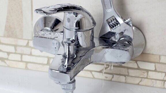 水管工用活动扳手修理漏水的水龙头DIY房子浴室淋浴保持工作修理漏水