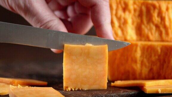 男用刀将切达干酪切成小块