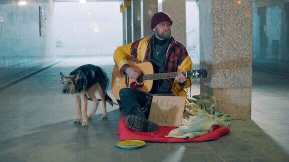 一个乞丐和他的狗在地下通道弹吉他