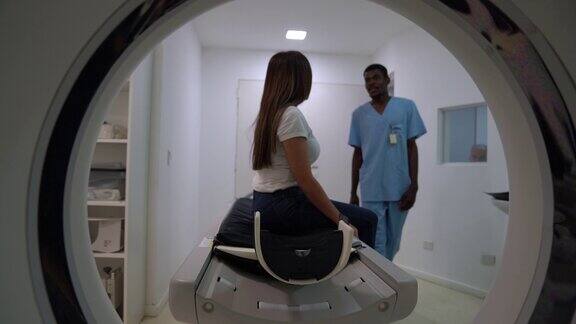黑人男性放射科医生非常愉快地向女性病人解释核磁共振扫描