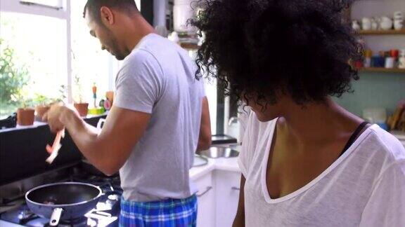 一对年轻夫妇在厨房里一起做早餐