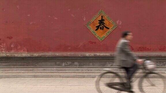 骑自行车经过一堵红墙