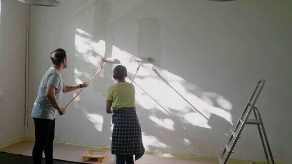 日本夫妇用油漆滚筒在家里刷墙