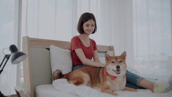 年轻女子与犬神娜在卧室休息