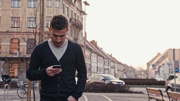 在城市中行走时输入短信的男子