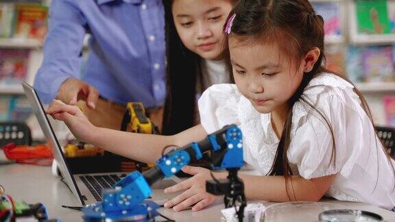 老师在教孩子们在教室里组装机器人和机器人教育理念、创新、技术、智慧和天才
