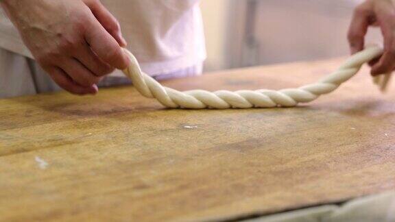 一个面目全非的面包师在面包房的厨房里做扭曲的面团
