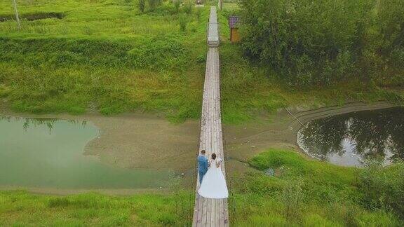 一对新婚夫妇在河上的桥上散步