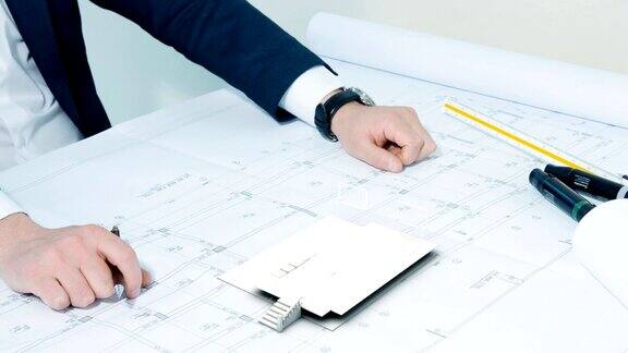 建筑师在桌子上工作与计划和建筑构造