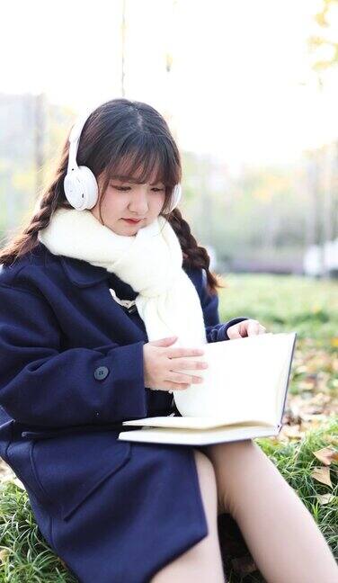 秋天一个女人在外面听音乐看书