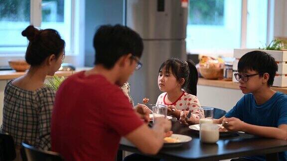 亚洲华人年轻家庭和两个孩子一起吃早餐周末早上一起在厨房