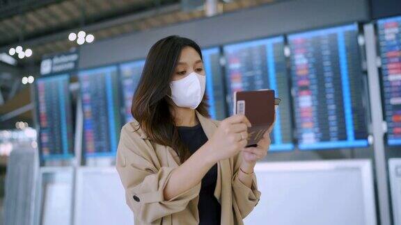 一名女乘客在机场戴着口罩发短信