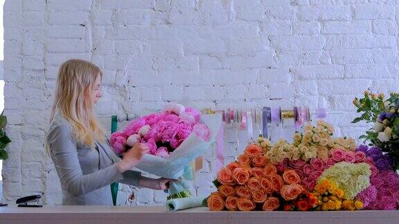 花商在花店用礼品纸包装鲜花