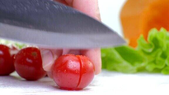 切红樱桃番茄与厨房刀在白板上白色背景近距离镜头全高清