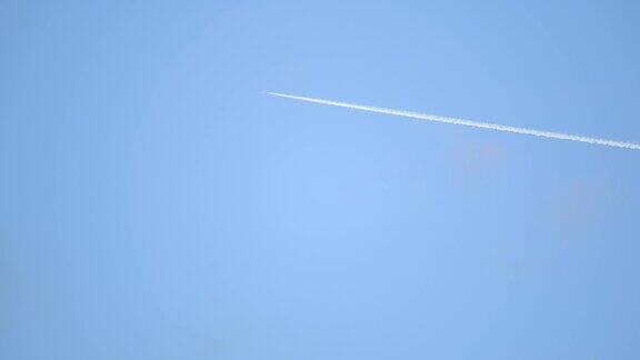 喷气式客机在高空飞行的场景在清澈的蓝天留下了尾迹