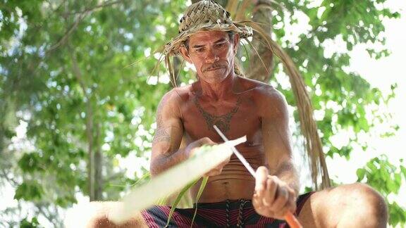 塔希提岛的博拉博拉岛一名传统的塔希提人正在用椰子叶制作帽子法属波利尼西亚