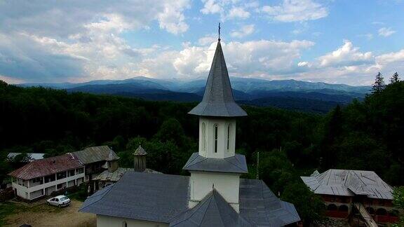 在绿色山顶的基督教教堂与山脉鸟瞰图