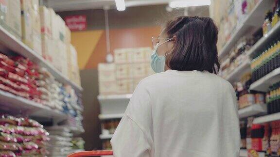 年轻女子戴着口罩在超市买干货