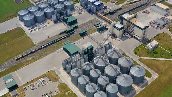自然界中的制造工厂农业粮食储罐绿色田野间的大型金属筒仓电梯鸟瞰图