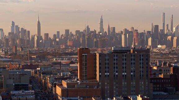 在阳光明媚的傍晚俯瞰纽约布鲁克林布什维克住宅区的曼哈顿中城无人机视频与平移摄像机运动