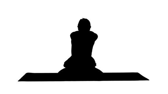 剪影运动美丽的年轻人练习瑜伽坐在AdhoMukhaPadmasana盘腿弯曲在变化莲花姿势