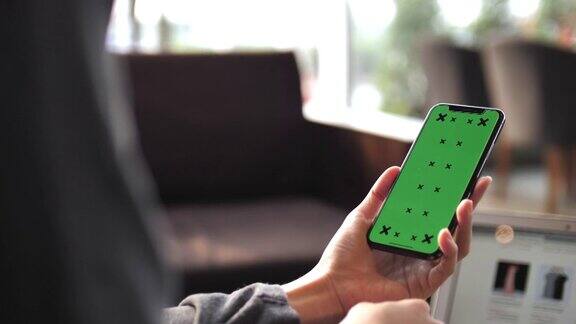 女人拿着绿色屏幕的智能手机