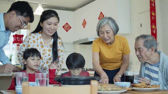 中国新年的家人坐下来给餐桌上带来食物