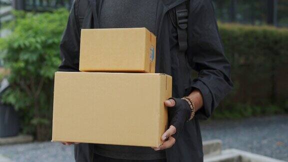 亚洲年轻的快递员拿着包裹盒子