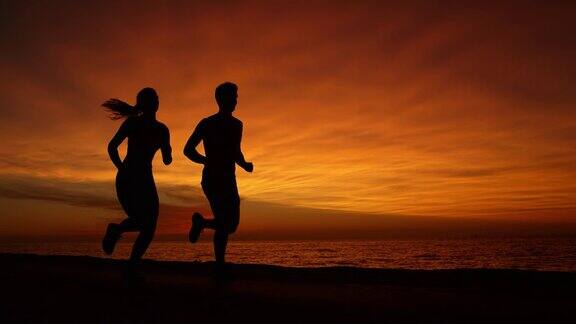 剪影:日落时分男性和女性一起在风景优美的道路上慢跑