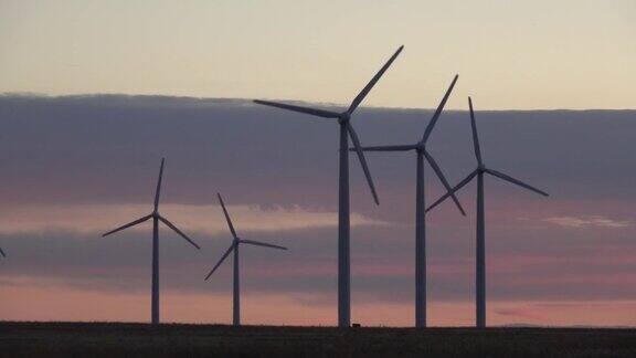 科罗拉多州波尼国家草原上旋转的风力涡轮机上的落日