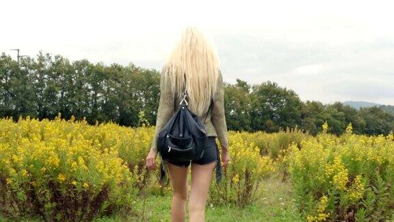 美丽的金发年轻女孩走在户外的自然的背影-框架斯坦尼康高清视频镜头