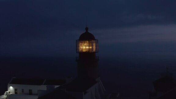 葡萄牙拉各斯黄昏时的灯塔头灯无人驾驶飞机在海的背景下盘旋