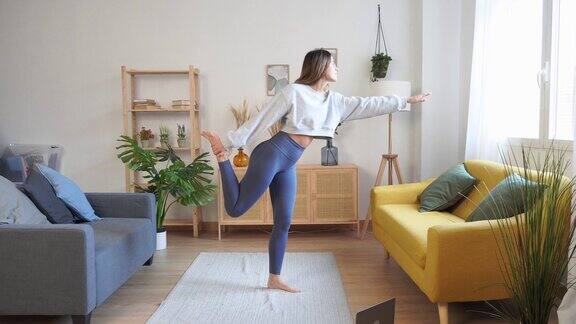 苗条的女人在客厅做瑜伽