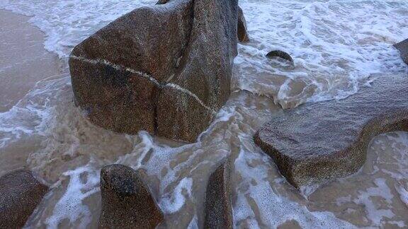 在沙滩上海水拍打着石头在石头之间流动