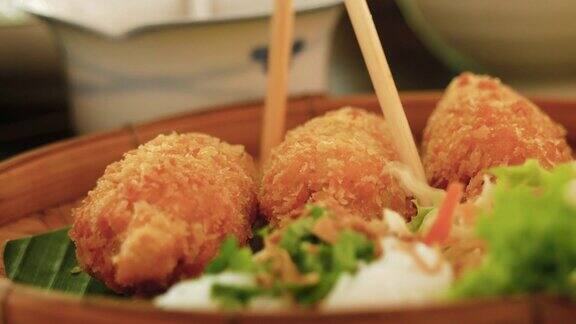 特写手用筷子挑炸虾和甘蔗在食物篮越南风格的食物